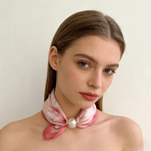 Pink silk scarf detail with pearl magnetic buckle, elegant triangle neck wrap accessory.