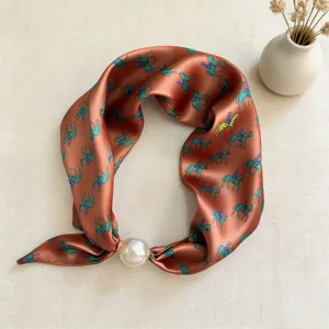 Elegant orange silk scarf with horse print and pearl buckle, chic neck accessory for women.