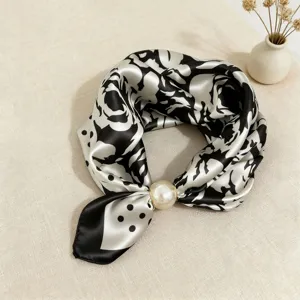 Detail view of a chic black and white silk scarf with pearl magnetic clasp, elegant and stylish.