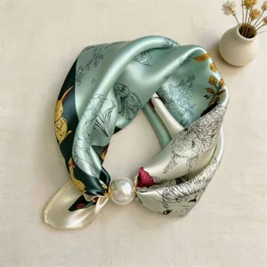 Close-up detail of silk neckerchief with animal print and magnetic pearl buckle.