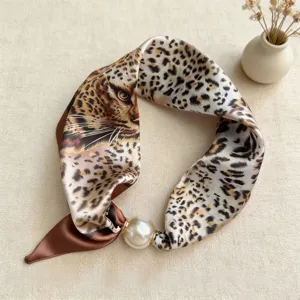 Detailed view of leopard print skinny silk scarf with elegant magnetic pearl buckle.