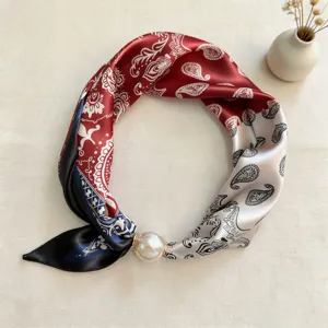 Detail view of a spring summer magnetic silk scarf with paisley pattern and elegant pearl clasp.
