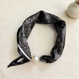 Closeup of black white paisley silk scarf with large pearl magnetic buckle elegant accessory