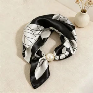 Detail view of a chic black and white silk scarf with pearl magnetic buckle, elegant neck accessory.