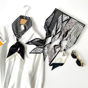 Detailed close-up of black and white patterned long scarves featuring elegant beaded necklace.