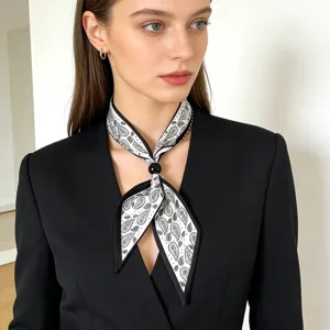 Detailed shot of a stylish white and black paisley print silk scarf necklace with black bead.