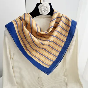 Detailed close-up view of this elegant yellow and blue striped cotton square scarf.