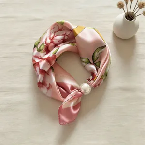 Vista dettagliata dell'elegante foulard in satin di seta rosa con anello di perla.