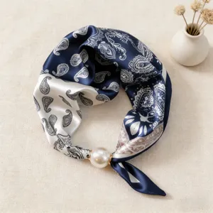 Vista detallada de pañuelo de seda paisley azul blanco con hebilla magnética de perla.