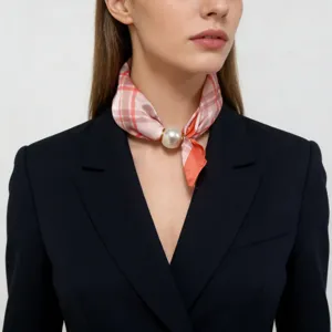 Detail shot of a chic pink plaid neck scarf with a large pearl magnetic clasp for women.