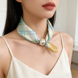 Close-up detail of plaid neck scarf with large pearl magnetic clasp, elegant daily neck wear.