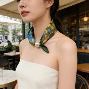 Close-up detail of artistic oil painting print neck scarf with elegant pearl magnetic clasp.