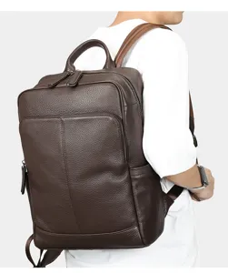 Detailed shot of the brown leather backpack worn by model, showing texture and design.