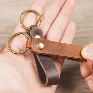 Gros plan du porte-clés de voiture en cuir véritable au design vintage avec anneaux en bronze.