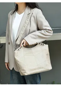 Genuine leather patchwork shoulder bag with chic metal studs, elegant commuter crossbody design.