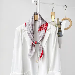 Elegant magnetic silk scarf detail showing plaid pattern and red accent on white blazer.