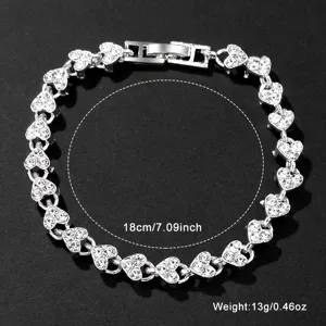 Detailansicht eines silbernen herzförmigen Armbands mit schimmerndem Kristallbesatz