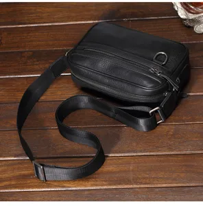 Dettaglio borsa a tracolla in pelle nera da uomo, borsa messenger in vera pelle con zip metallica.