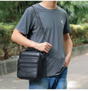 Men's vertical leather shoulder bag, detailed view of multi-pocket crossbody design.