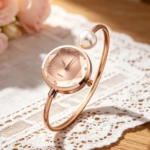 Elegante roségoldene Quarzuhr mit facettiertem Zifferblatt und Perlenarmband-Detail