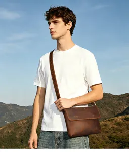 Outdoor scene detail shot of a stylish mens brown crazy horse leather messenger bag.