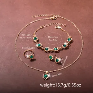 Elegantes goldfarbenes Herz-Schmuckset mit grünen Kristallen, Halskette und Armband.