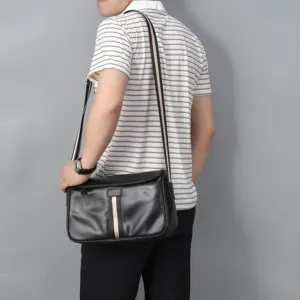 Detail view of a black genuine leather men's shoulder bag with striped webbing accent.