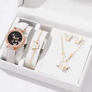 Detailansicht eines eleganten weißen Schmetterlings-Schmucksets mit Uhr und Halskette.