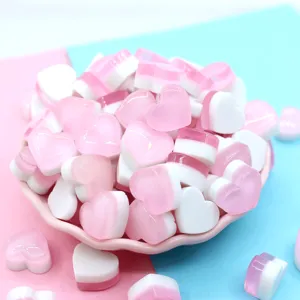 Macro view of pink and white heart resin charms for DIY slime and craft decoration.