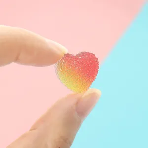 Makroaufnahme eines herzförmigen Harz-Gummibärchens mit Farbverlauf und Zuckerstruktur