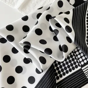 Schwarzes und weisses gepunktetes Satintuch Detail mit eleganter geometrischer Muster.
