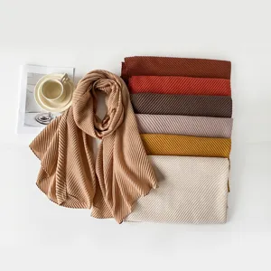 Close-up of elegant pleated solid color scarves in earth tones and soft hues