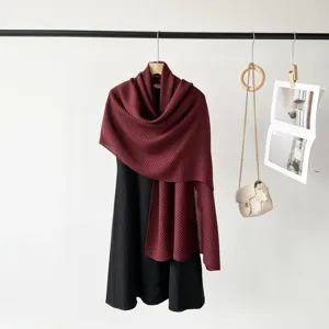 Elegant burgundy pleated scarf draped over black dress with fashion accessories