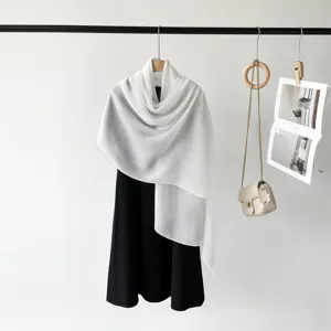 Close-up detail of white pleated scarf showing elegant and fine accordion textures