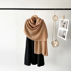 Close-up of tan pleated imitation silk scarf showing elegant drape and fine texture.