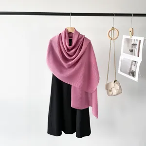 Close-up showing the fine texture of a pink pleated scarf draped over a black dress