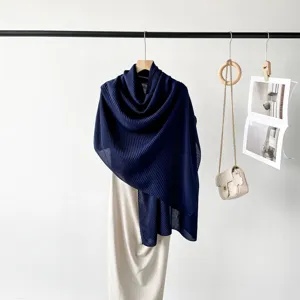 Detailed macro shot showing the fine pleated texture of the navy blue cotton-linen shawl