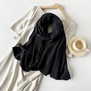 Detail view of black pleated scarf featuring elegant organ texture and lifestyle styling