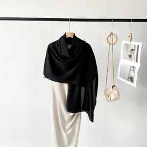 Close-up of black pleated scarf styled over a dress for a minimalist fashion look