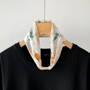 Chic floral print small silk scarf with magnetic buckle accessory, elegant neckwear detail.