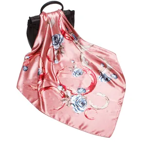 Silk square scarf detail showing blue roses print and smooth satin texture on elegant drape.