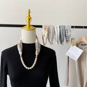 Detailed view of the elegant pearl magnetic clasp necklace paired with a vintage silk scarf.