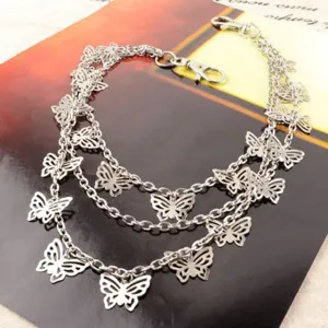 Detail shot of the multi-layer silver butterfly chain, showcasing delicate hollow metal charms.