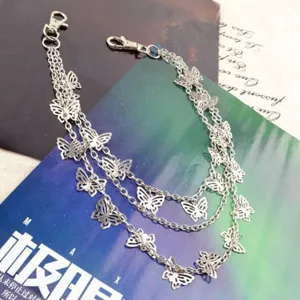 Detail view of a silver multi-layer butterfly waist chain, delicate metal pants accessory.