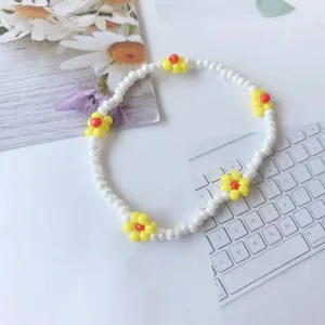 Delizioso braccialetto di perline margherita con perle bianche e fiori gialli. Vista dettaglio.
