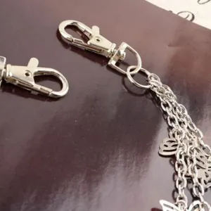 Silver metal waist chain with hollow butterfly charms and lobster clasps close-up view.