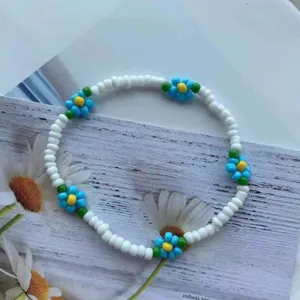 Primo piano dettagliato di un vivace braccialetto di margherite di perline con fiori.