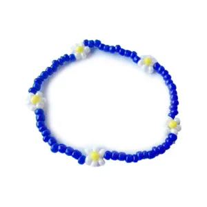 Primo piano dettagliato del braccialetto di perline blu con graziosi fiori di margherita.