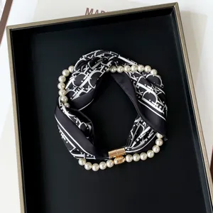 Exquisite black and white printed silk scarf paired with pearl magnetic necklace detail.