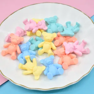 Macro view of colorful matte resin bear DIY craft accessories scattered on a white plate.